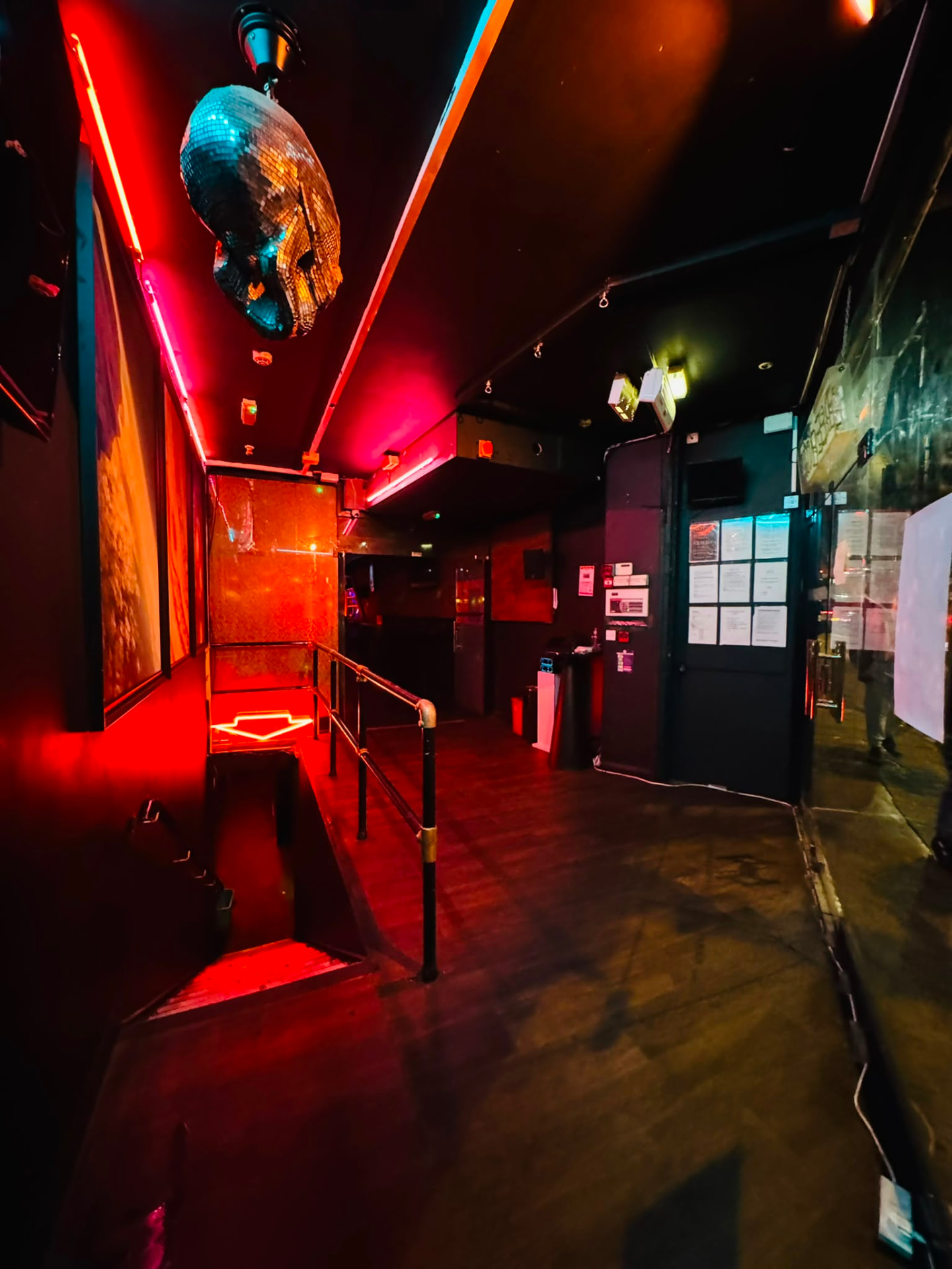 Entrance stairway with a mirrored disco skull and red neon strips