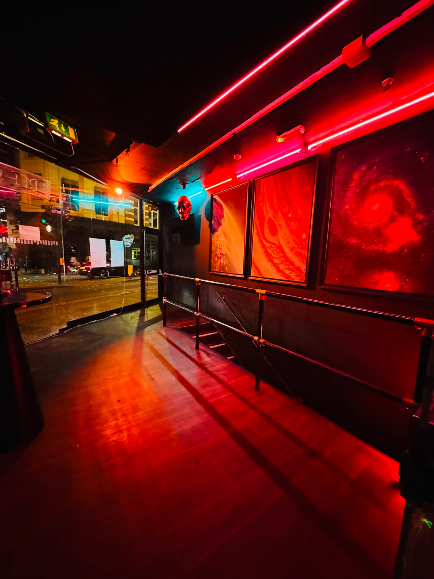 Front window seating with red neon tubes and space artwork on the wall