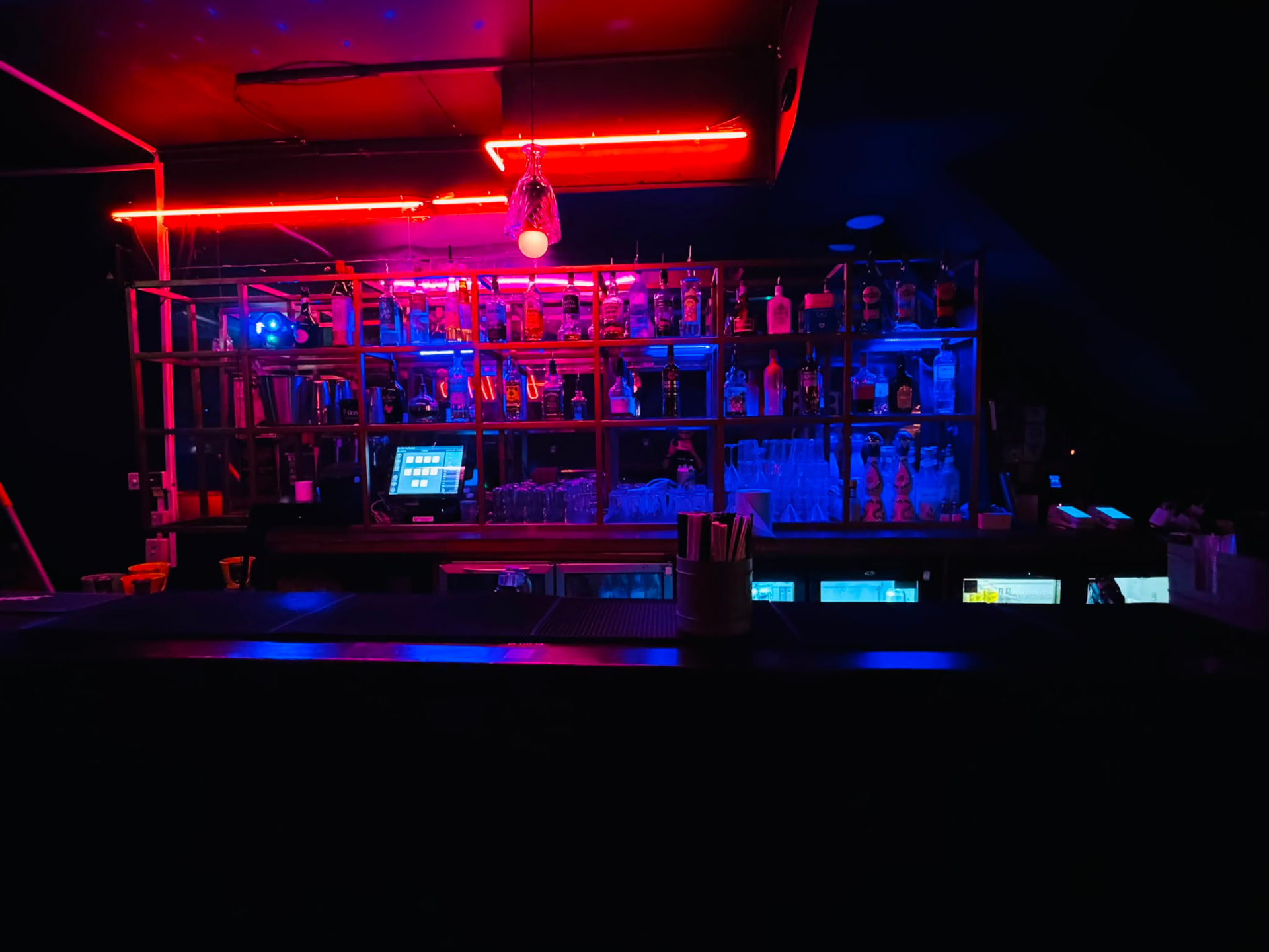 The bar at 331 Old St glowing under red neon with a blue-lit back bar