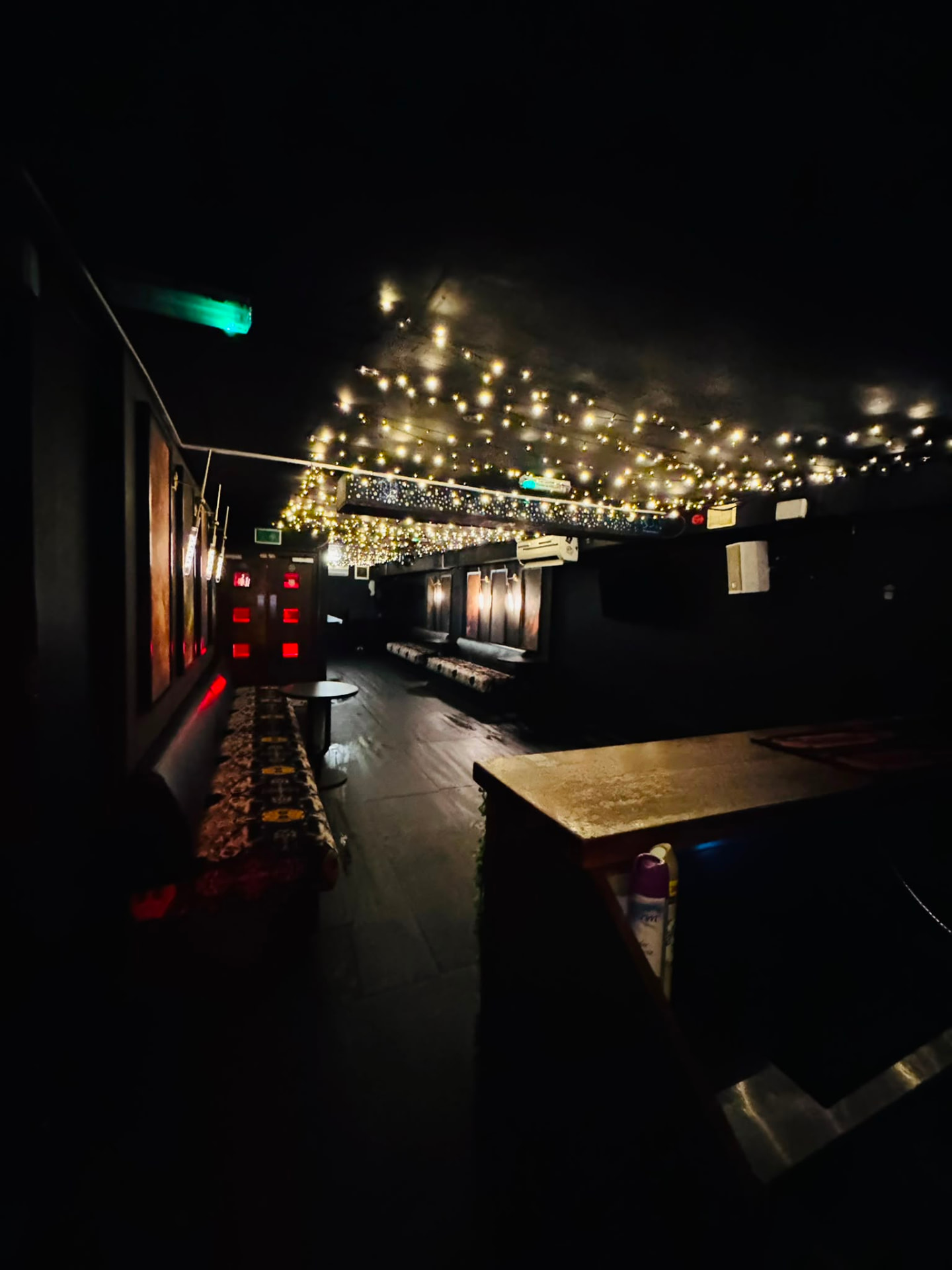Lounge area with a canopy of warm fairy lights above the seating